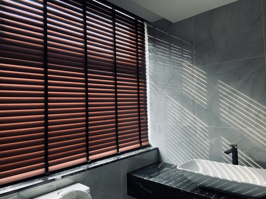 Wooden venetian blinds installed in a modern bathroom to enhance privacy, sunlight control, and elegant interior style.