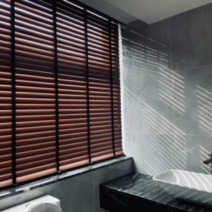 Wooden venetian blinds installed in a modern bathroom to enhance privacy, sunlight control, and elegant interior style.