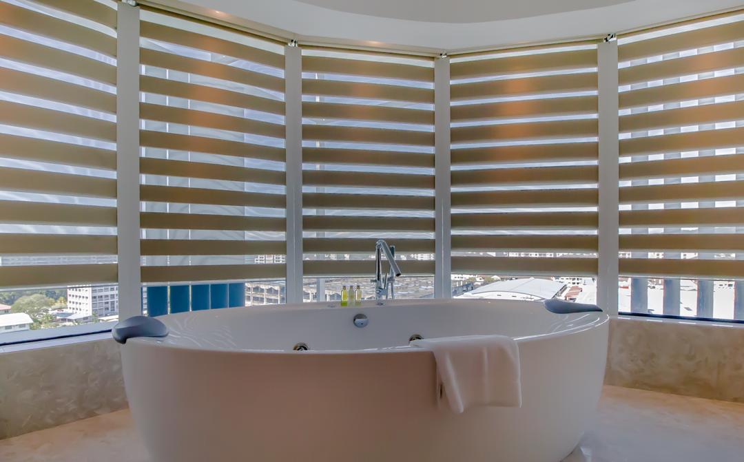 Zebra blind curtain installed around bathroom windows for privacy, light control, and a modern interior look.