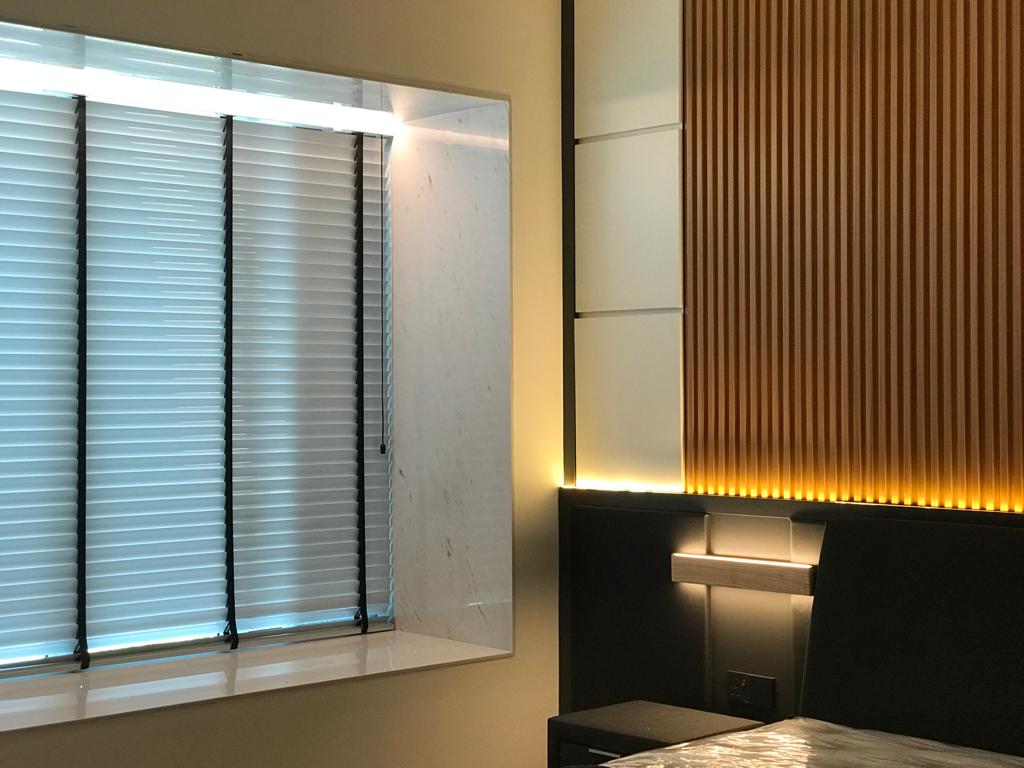 Wooden venetian blinds in a modern bedroom, adding soft light control, privacy, and a refined window finish.