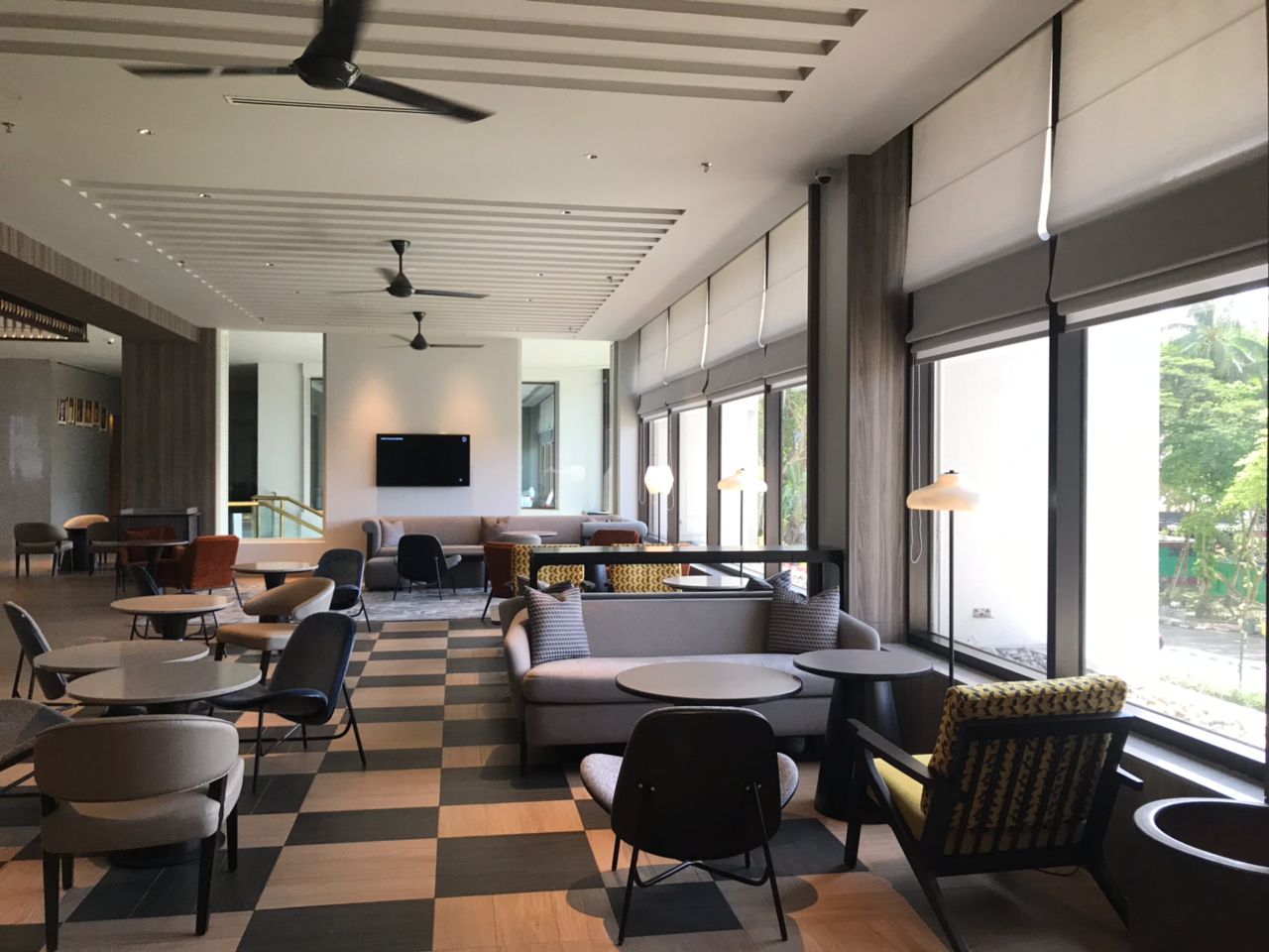 Roman blinds installed across tall lounge windows, creating soft privacy, natural light control, and a refined modern interior finish.