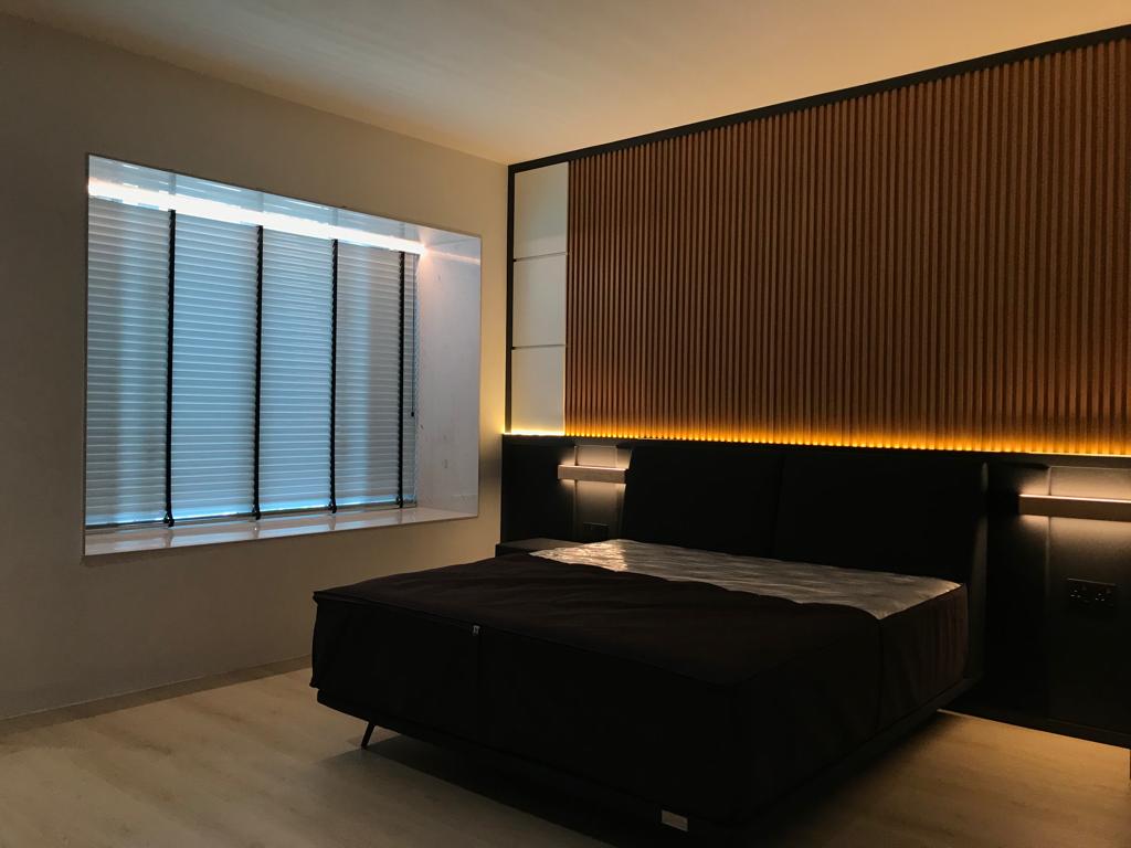 Wooden venetian blinds in a modern bedroom, creating gentle privacy, controlled daylight, and a warm refined interior finish.
